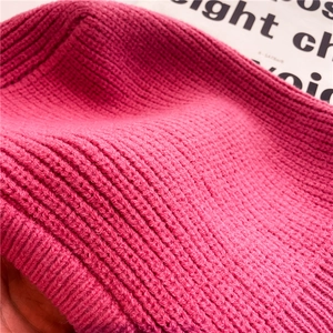 Dettaglio ravvicinato della trama a maglia a coste rosa acceso di un passamontagna