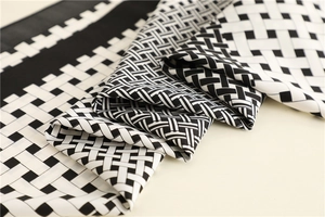Close-up of black and white woven check silk scarf with soft twill texture and hemmed edge