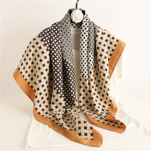 Elegant beige and brown geometric knit silk scarf draped on a white hanger for women
