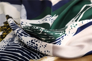 Detail van een zijden sjaal met geometrische print en zachte, glanzende textuur