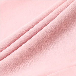 Macro detail of soft pink cotton knitted fabric texture showing fine weave patterns