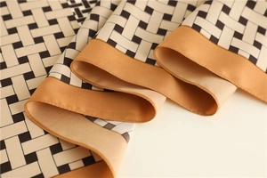Close-up of woven lattice silk scarf showing smooth texture and amber borders