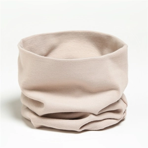Close-up of soft beige cotton knit neck warmer showing fine texture and elasticity