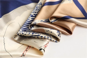 Detailopname van satijnen sjaal met golfprints en zijdeachtige textuur in blauw en goud