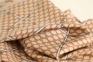 Detailed close-up of luxury silk scarf showing intricate chain patterns and soft texture