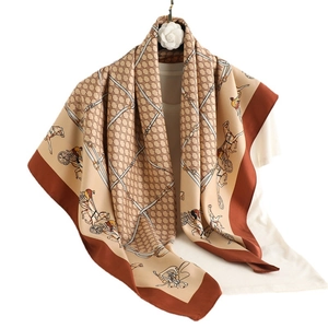 Luxury horse carriage print silk scarf in camel and brown tones hanging on white