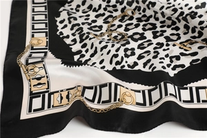 Close-up of leopard print satin scarf with golden chain patterns and silky texture