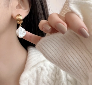 Detailed view of French baroque pearl earring with textured gold-plated metal base