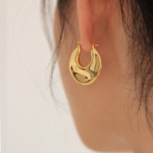 Minimalist thick gold-plated geometric hoop earrings shown on a model for a chic look