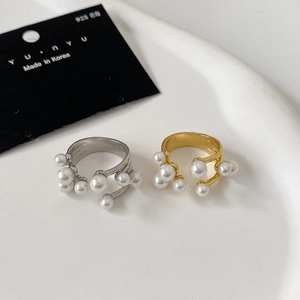 Anelli aperti multistrato color oro e argento con perle su vassoio bianco