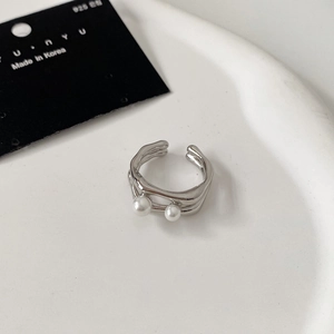 Macro di un anello aperto a doppio strato in argento 925 con due perle bianche