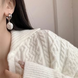Baroque freshwater pearl earrings with silver spiral texture studs on a female model