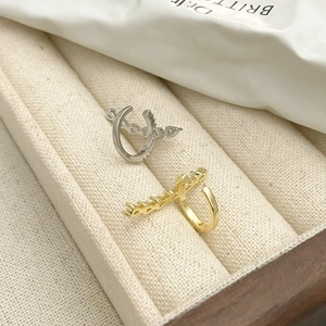 Detail of horseshoe-shaped zircon ear cuffs in gold and silver finish on velvet
