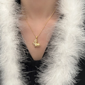 Elegant gold butterfly pendant necklace with sparkling crystal inlay worn by model