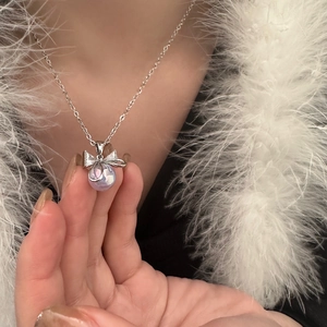 Detail of bow-knot necklace with lavender pearl and zircon inlay on silver chain