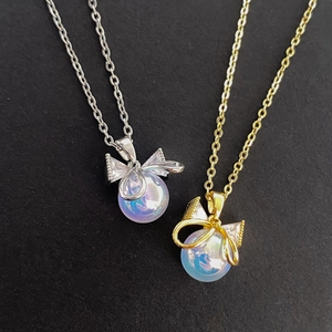 Iridescent pearl bow necklace in gold and silver finish with sparkling zircon accents