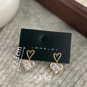 Detail view of heart-shaped gold earrings with micro-set cubic zirconia and 2.1cm length