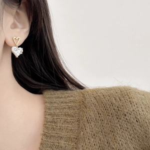 Gold-plated hollow heart earrings with large clear zircon pendant worn by model