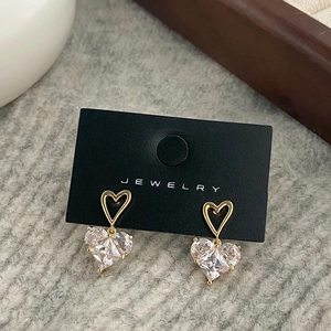 Detail of gold plated heart earrings with sparkling cubic zirconia on jewelry card