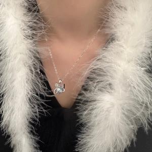 Sparkling bow and pearl pendant necklace for women on elegant white feather background