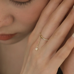 Adjustable gold star charm ring with pave zircon chain for women in warm lighting