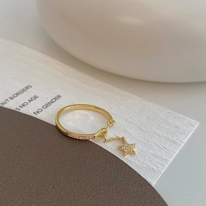 Detail of gold chain star ring featuring pink zircon pavé setting on a white display card