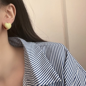 Exquisite gold-plated heart hoop earrings with textured matte finish on female model