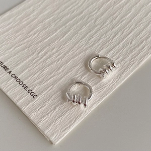 Détail de boucles d'oreilles créoles en argent avec cinq petits anneaux imbriqués