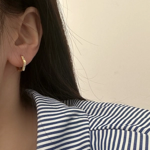 Minimalist gold hexagonal earrings with micro-set zircons on female model