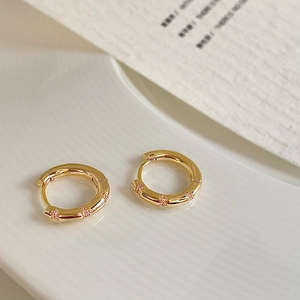 Macro shot of 14K gold plated huggie earrings with micro-pave cubic zirconia crystals