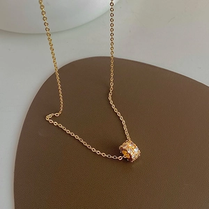 Elegant gold-plated cylinder necklace with sparkling zircon crystals on leather pad