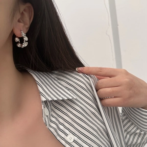 Textured wave ruffle hoop earrings in silver plating shown on a female model
