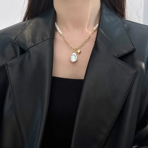 Baroque freshwater pearl necklace with heart pendant on a stylish black leather blazer