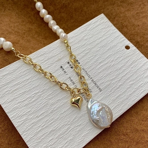 Baroque pearl and gold chain necklace featuring heart charm and irregular pearl pendant