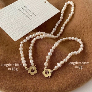 Dettaglio del set collana e bracciale di perle barocche con chiusura a fiore dorato