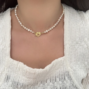 Collier élégant en perles d'eau douce avec un fermoir à bascule en forme de fleur dorée
