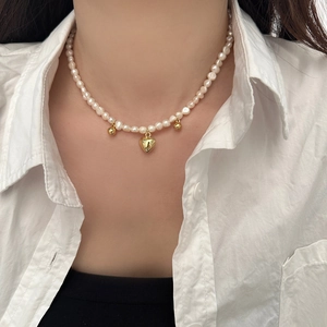 Collier élégant en perles d'eau douce avec pendentif cœur doré sur un mannequin