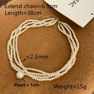 Detail of multi-strand pearl necklace with teardrop pendant and adjustable metal chain
