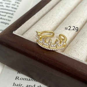 Detailed view of crown shaped ring with pearls and zircons on warm wood tray