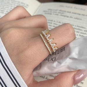 Detail of layered gold crown ring with zircon teardrops and pearls on model's hand