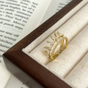 Elegant gold crown open ring with marquise crystals and tiny pearls on vintage book