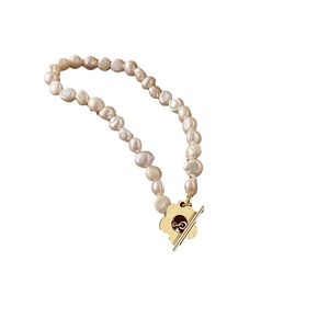 Collana di perle d'acqua dolce barocche con chiusura a fiori dorata su sfondo bianco