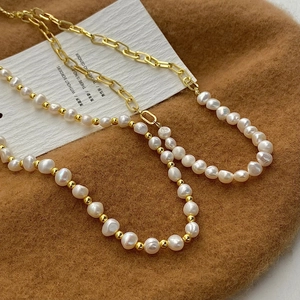 Baroque freshwater pearl necklace with gold paperclip chain link on dark velvet