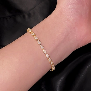 Elegantes vergoldetes Tennisarmband mit Zirkonia-Steinen auf schwarzem Seidenstoff