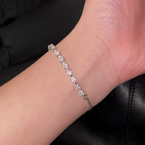Detail eines verstellbaren Silberarmbands mit funkelnden Zirkonsteinen im Birnenschliff