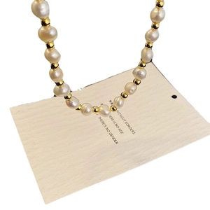 French Baroque freshwater pearl necklace with irregular pearls and golden beads on card