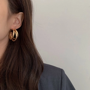 Three-tier overlapping gold hoop earrings for women shown on model for daily wear