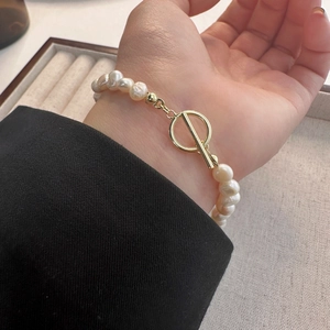 Elegant natural freshwater pearl bracelet featuring a gold OT toggle clasp on a female wrist