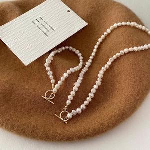Detailed view of baroque pearl necklace and bracelet set with golden T-bar toggle clasp