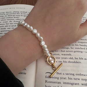 Bracelet en perles de culture baroques avec fermoir OT doré sur fond de livre ouvert